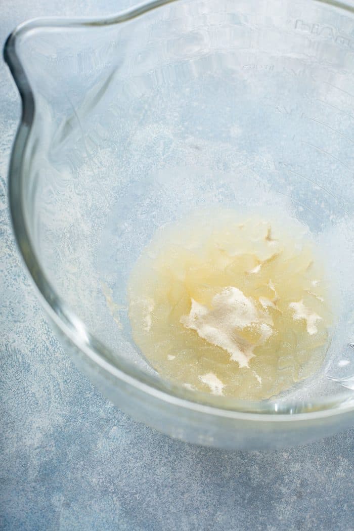 Gelatin being dissolved in water in a glass mixing bowl