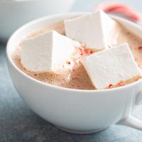 Three homemade marshmallows floating in a mug of hot chocolate