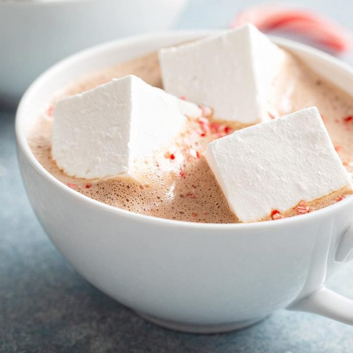 Three homemade marshmallows floating in a mug of hot chocolate