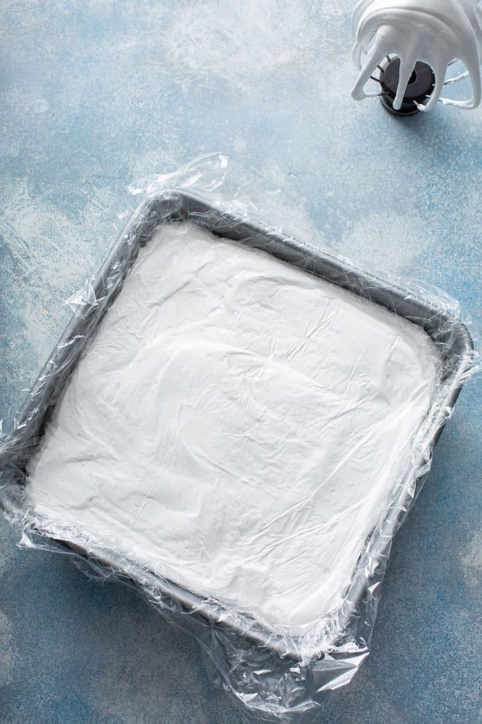 Pan of homemade marshmallows topped with plastic wrap, ready to rest overnight