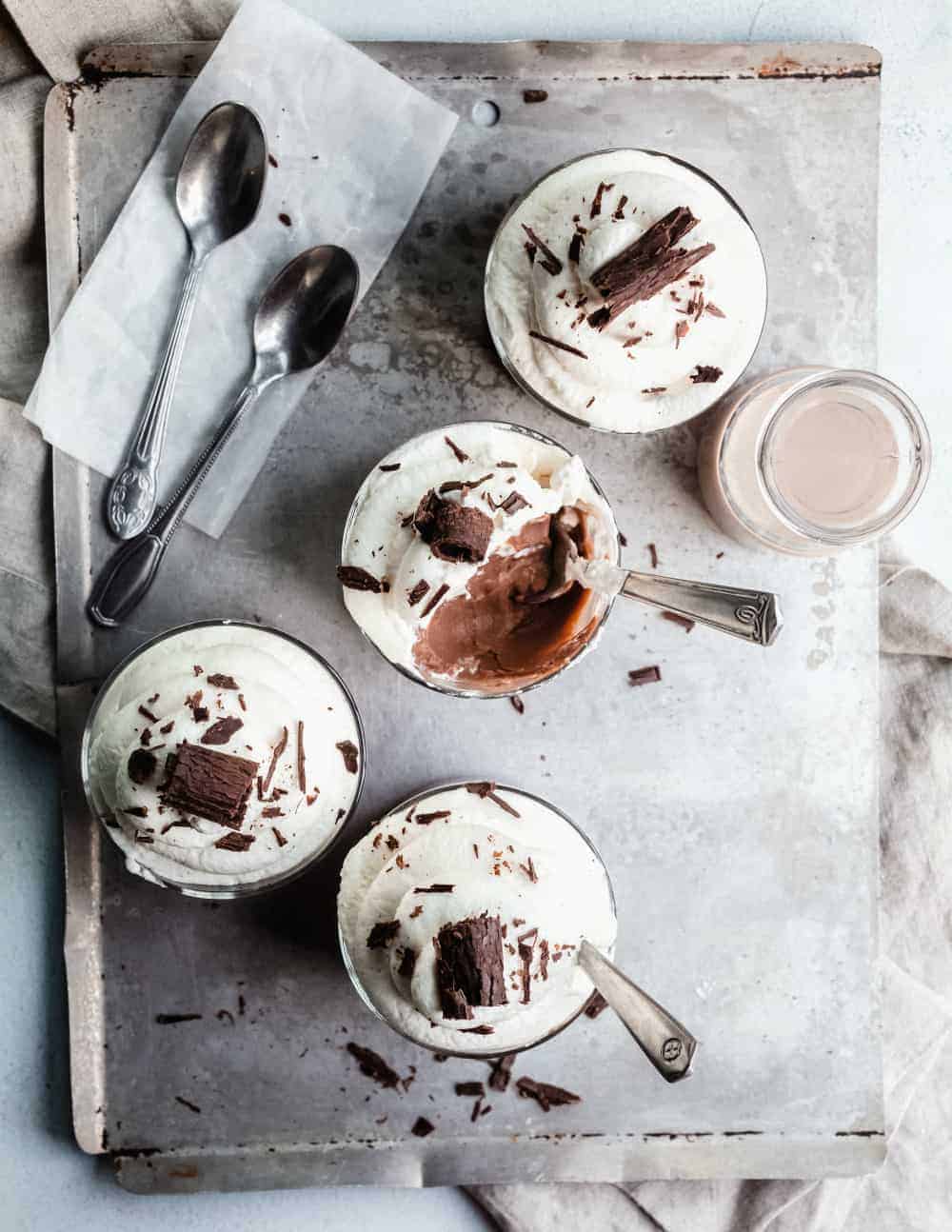 Homemade chocolate pudding in 4 small serving dishes, with several bites taken out of the middle dish