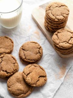 Chai sugar cookies stacked next to a glass of milk