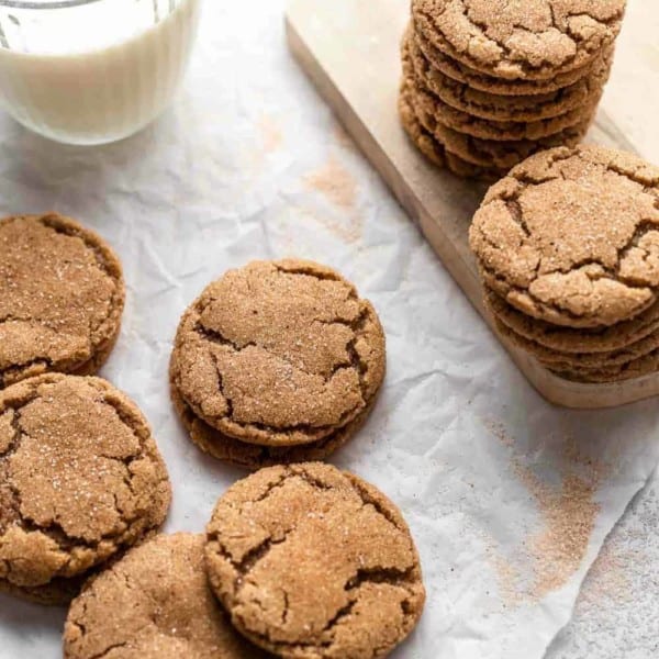 Chai sugar cookies stacked next to a glass of milk