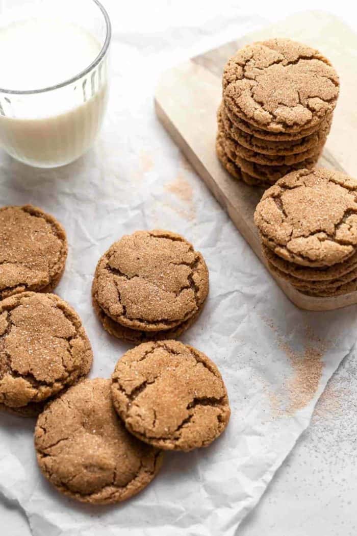 Chai sugar cookies stacked next to a glass of milk