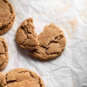 Chai sugar cookie broken in half on a piece of parchment paper