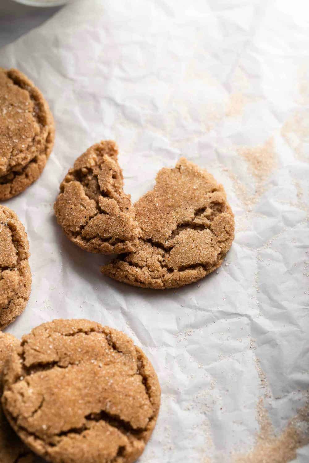 Chai sugar cookie broken in half on a piece of parchment paper