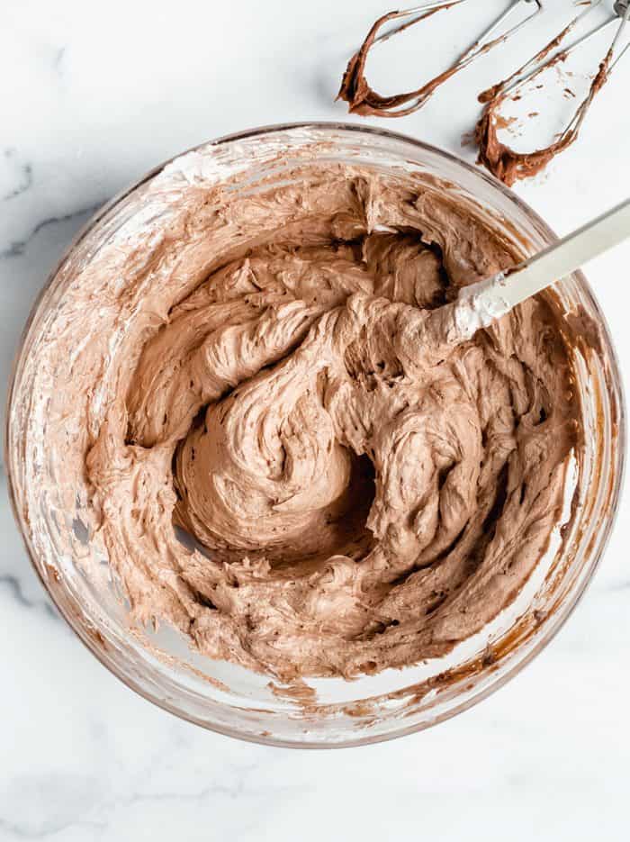 Filling for no bake nutella cheesecakes in a glass mixing bowl on a marble counter