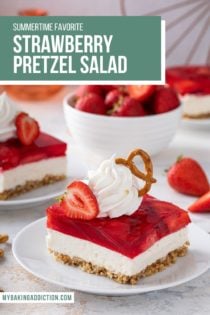 White plate with a slice of strawberry pretzel salad on it. The dessert is topped with whipped cream and a pretzel. Text overlay includes recipe name.