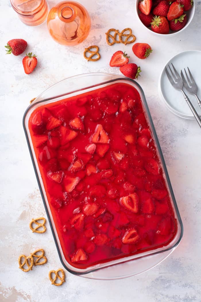 Overhead view of assembled strawberry pretzel salad in a glass baking dish.