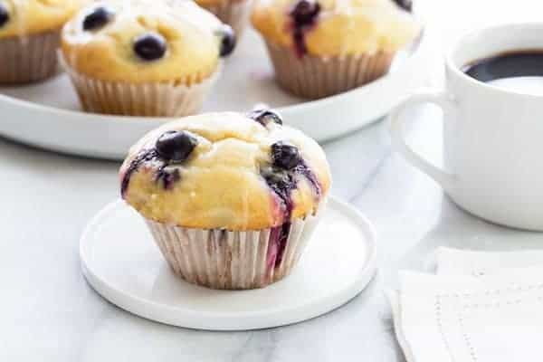 Blueberry Doughnut Muffins are topped with a sweet and tangy lemon glaze.  Perfect with a cup of afternoon tea or your morning coffee!