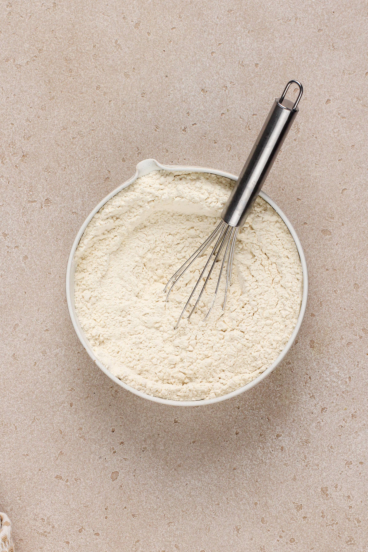 Dry ingredients whisked together in a white bowl.