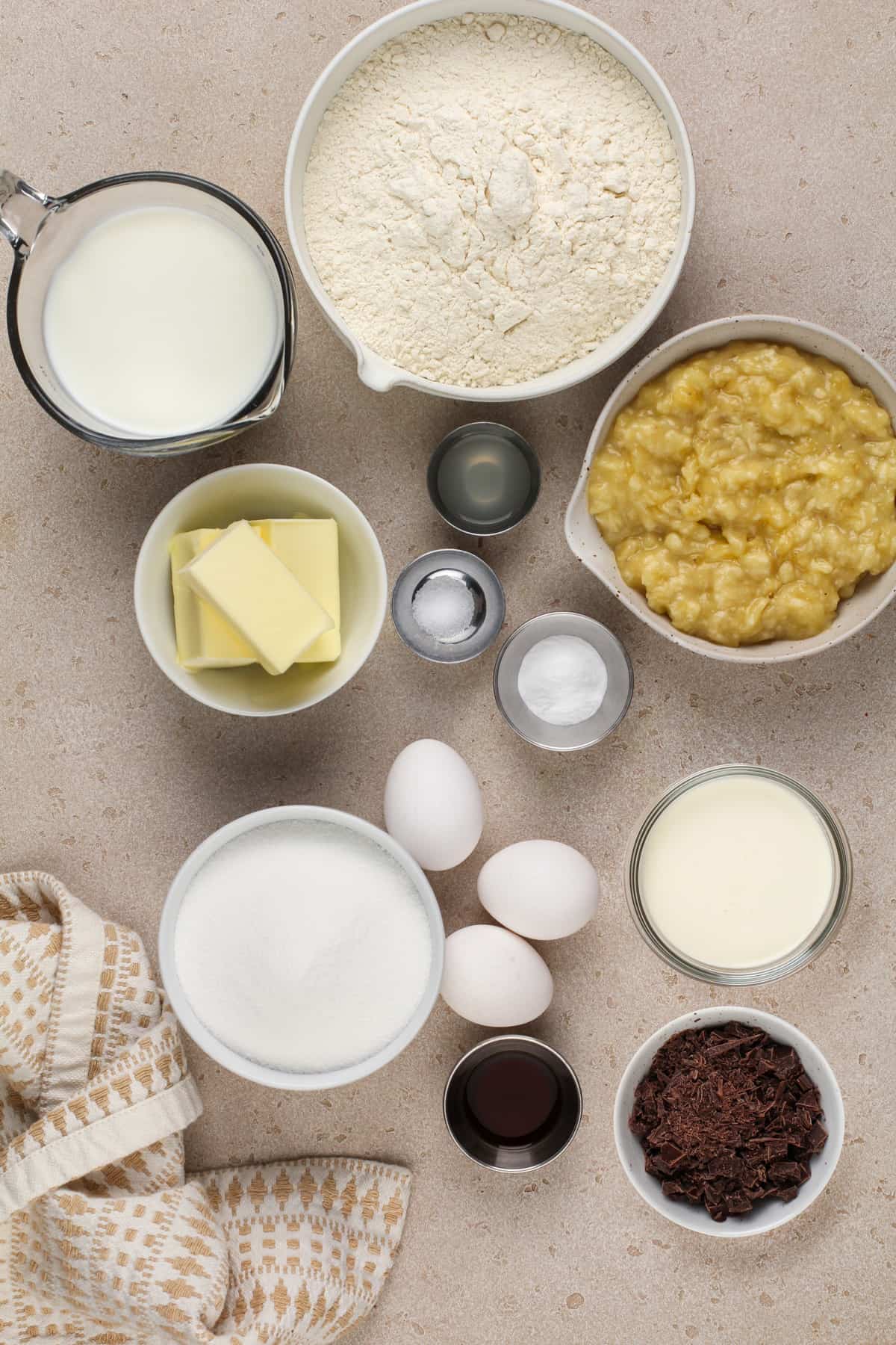 Banana bundt cake ingredients arranged on a beige countertop.