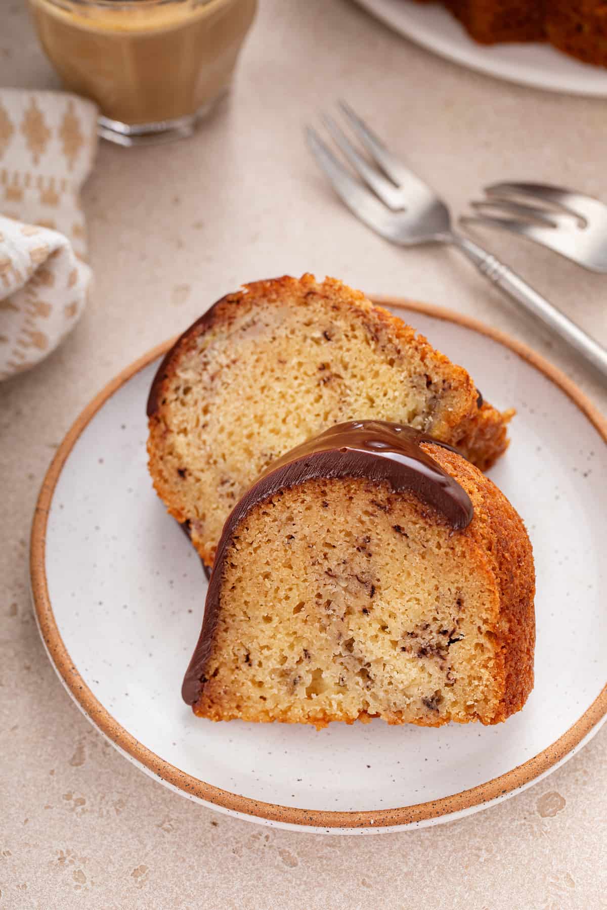 Two slices of banana bundt cake leaning against each other on a plate.
