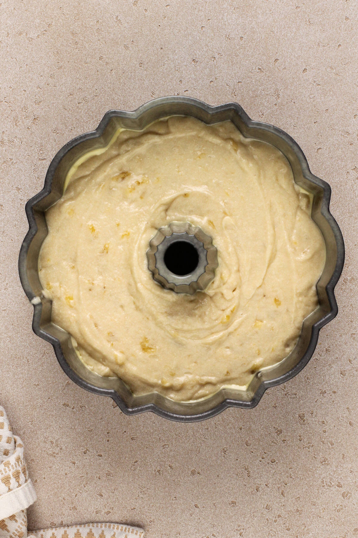 Banana bundt cake batter in a bundt pan, ready to go in the oven.