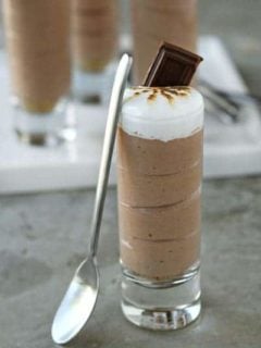 S'mores shot with a small spoon leaning up against the glass on a stone surface