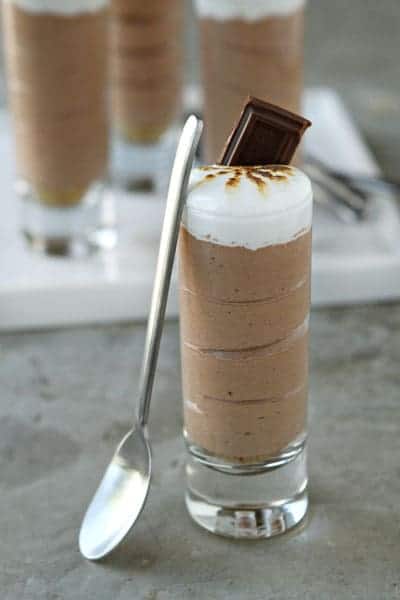 S'mores shot with a small spoon leaning up against the glass on a stone surface