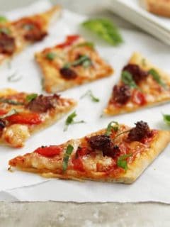 Slices of grilled pizza on parchment paper on a stone surface