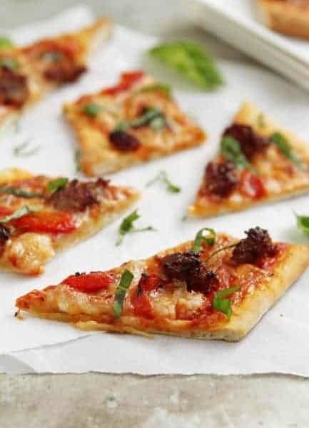 Slices of grilled pizza on parchment paper on a stone surface