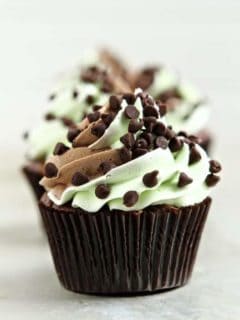 Close up of a mint chocolate chip cupcake on a marble surface
