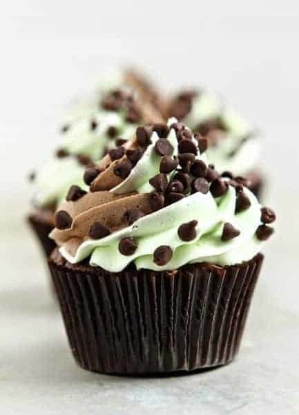 Close up of a mint chocolate chip cupcake on a marble surface