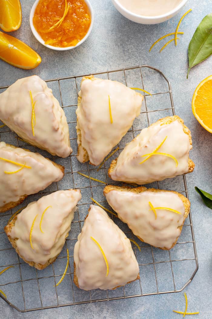 Baked and glazed orange scones arranged on a cooling rack