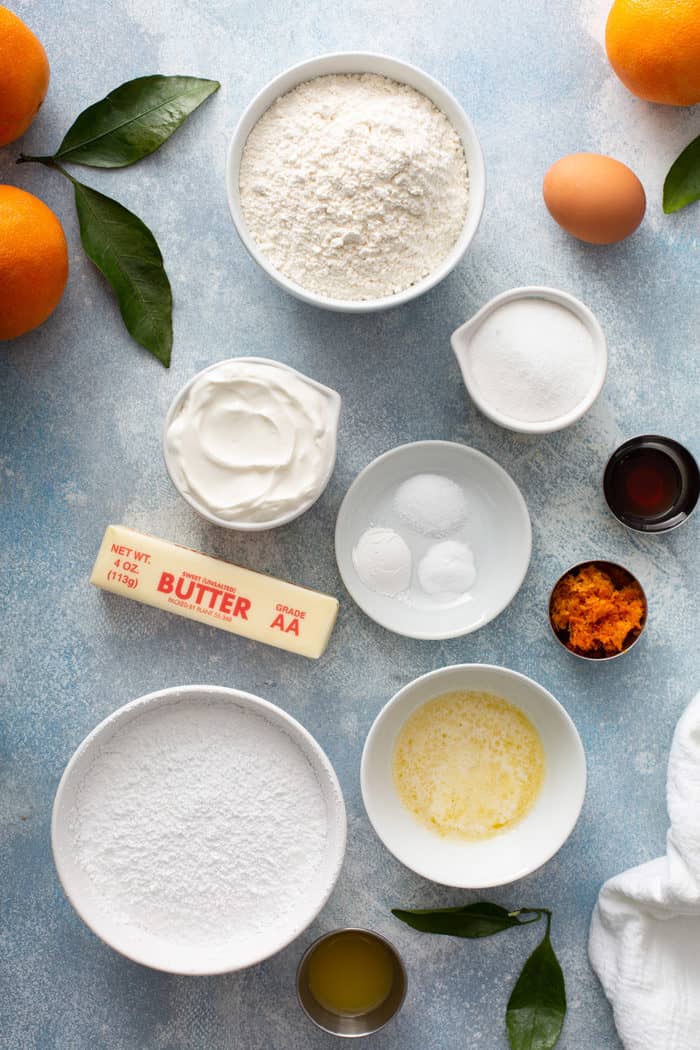 Ingredients for orange scones on a blue countertop