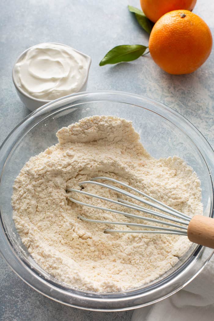 Whisk mixing together the dry ingredients for orange scones in a glass mixing bowl