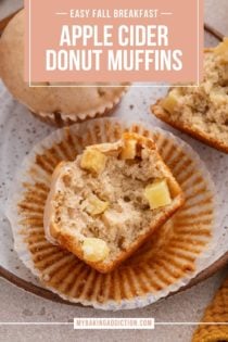 Halved apple cider donut muffin on a plate, showing the chunks of apple in the muffin. Text overlay includes recipe name.