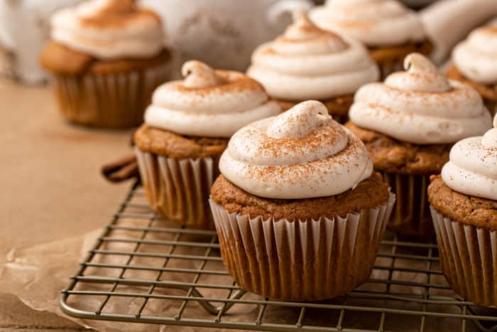 Frosted pumpkin spice cupcakes on a wire cooling rack