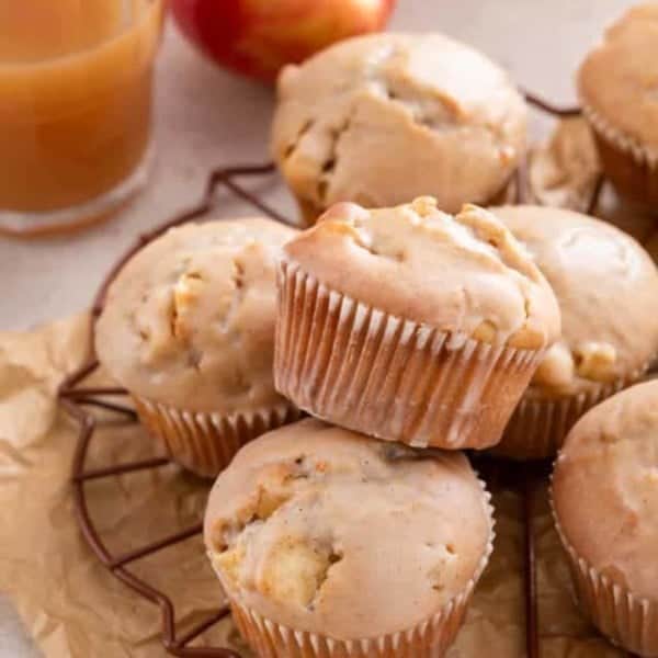 Glazed apple cider donut muffins arranged on a wire rack.