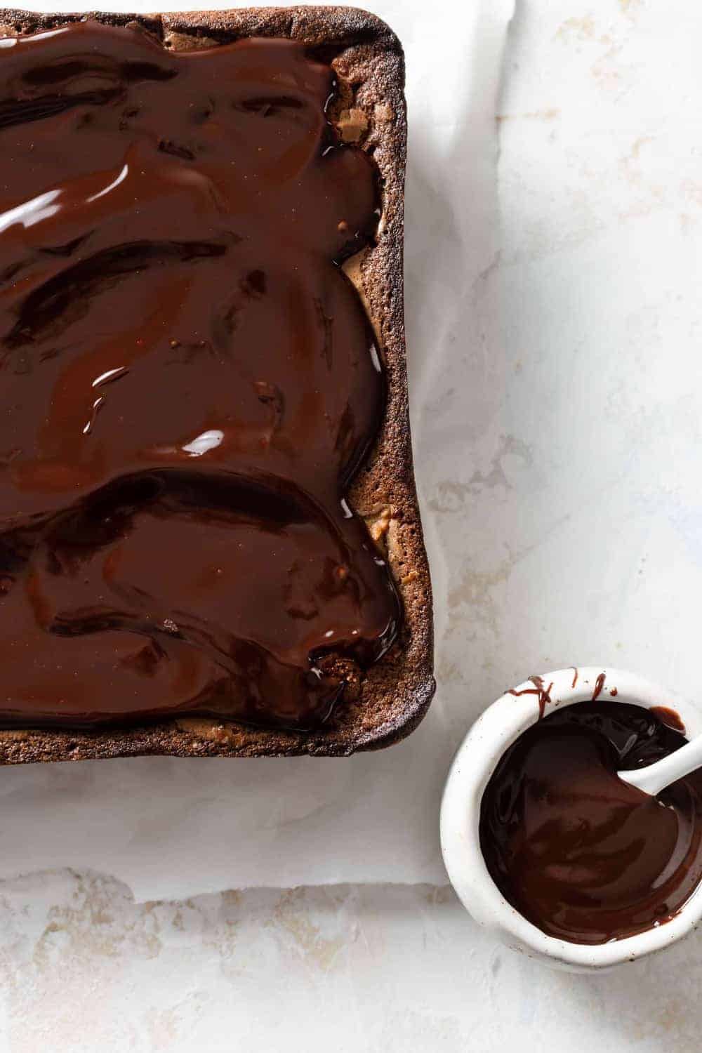 Chocolate ganache next to pumpkin brownies recently topped with ganache