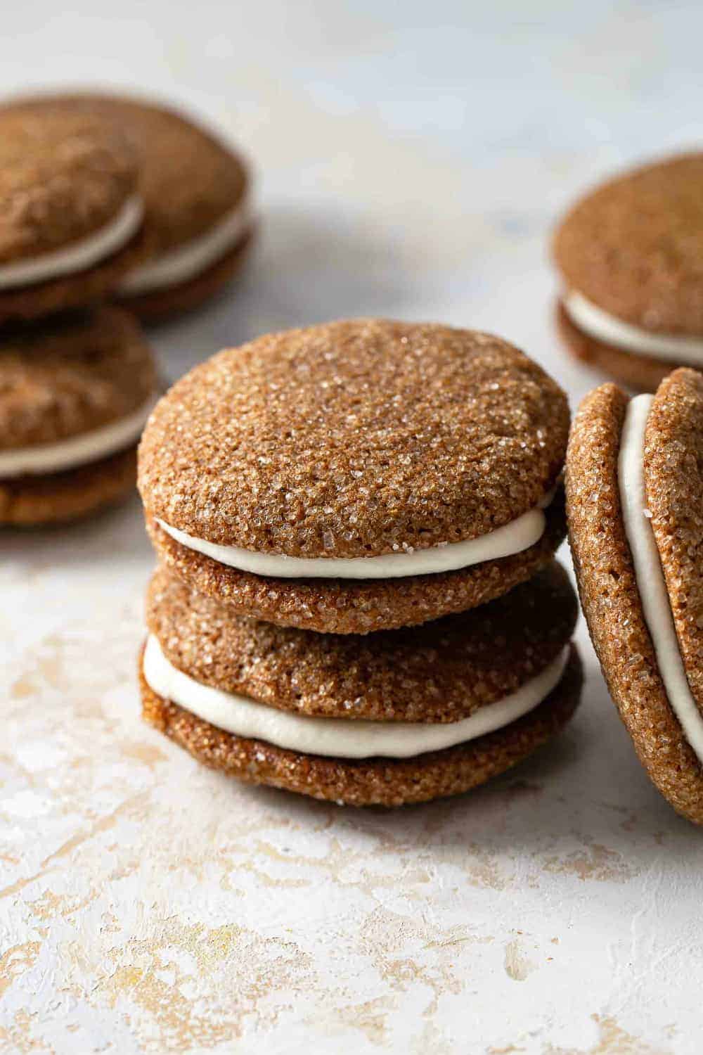 Pumpkin molasses sandwich cookies stacked on a countertop
