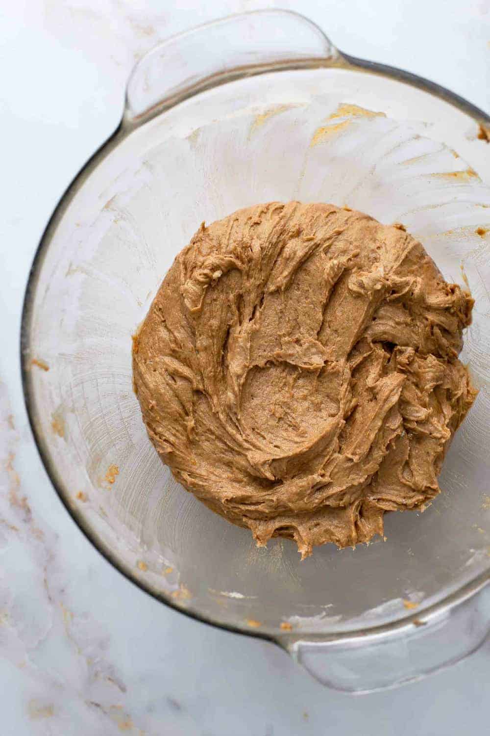 Dough for pumpkin molasses cookies in a glass mixing bowl