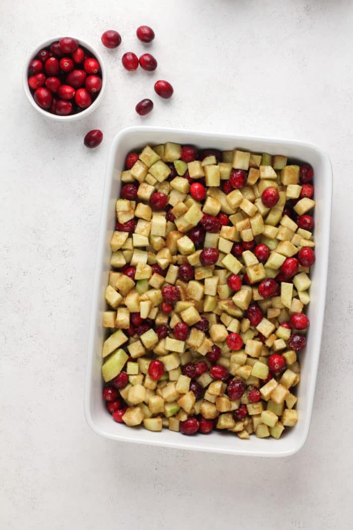 Cranberry apple crisp filling in a white baking dish.