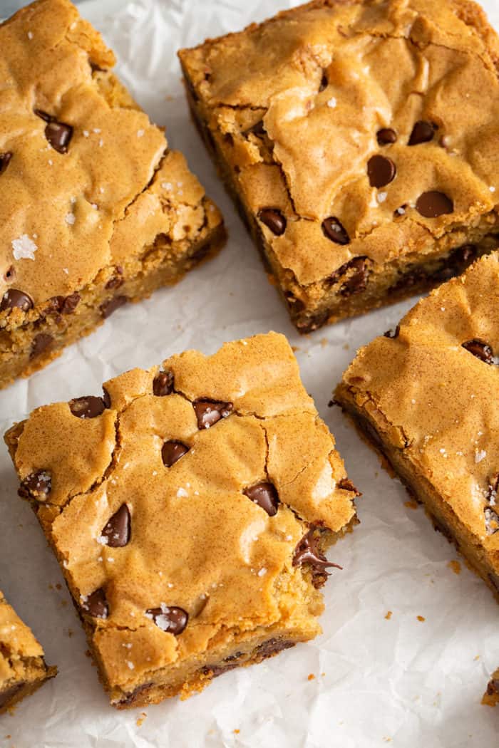 Cut Chocolate Chip Blondies on a piece of parchment paper