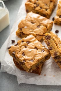 Stacked chocolate chip blondies on a piece of parchment paper