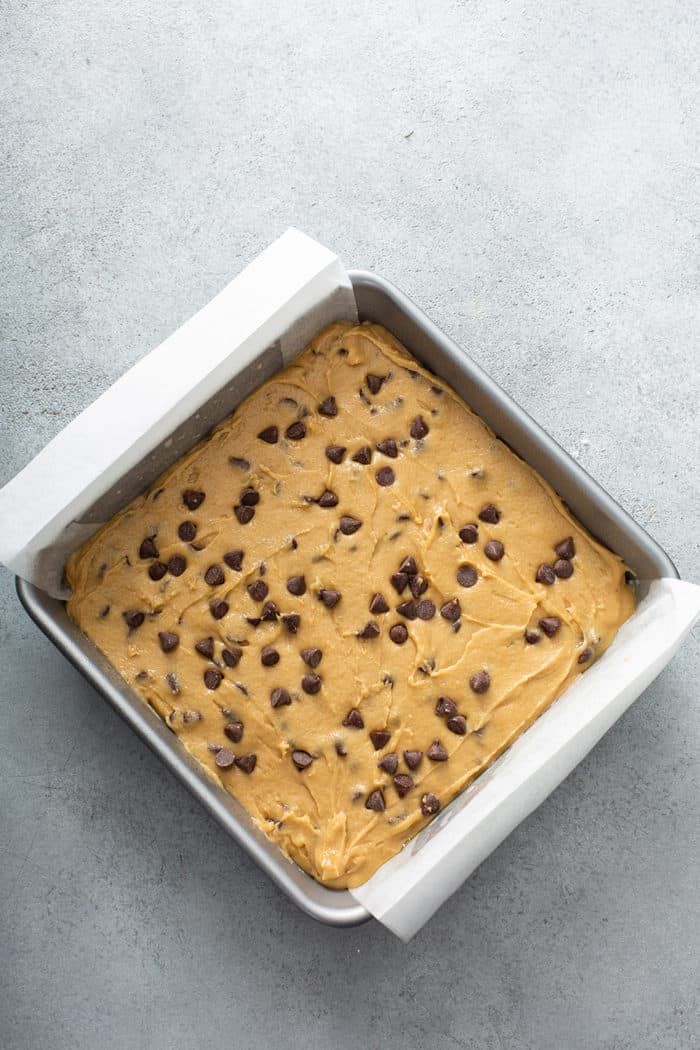 Unbaked chocolate chip blondies in a metal baking pan, ready to bake