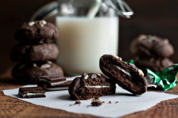 A mint chocolate cookie cut in half sitting on parchment paper