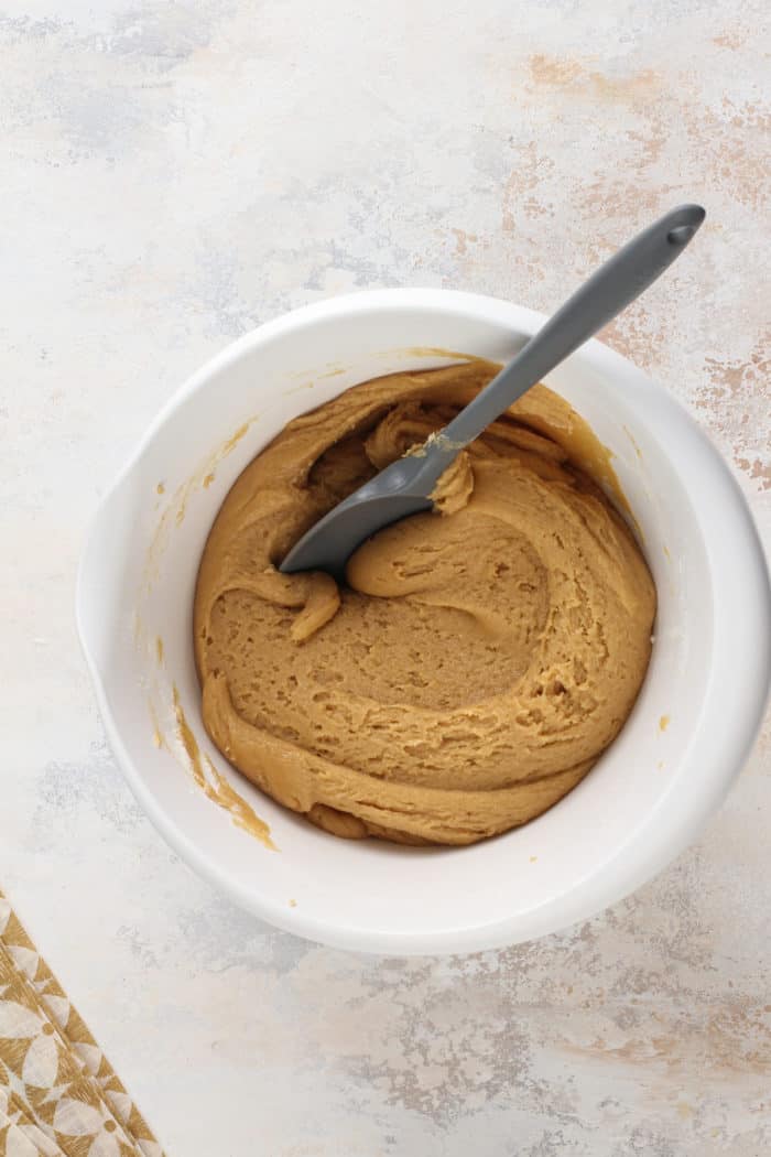 Honey peanut butter cookie dough in a white mixing bowl.