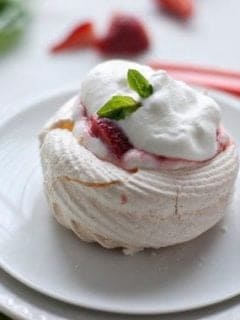 A meringue next on a round plate next to a fork