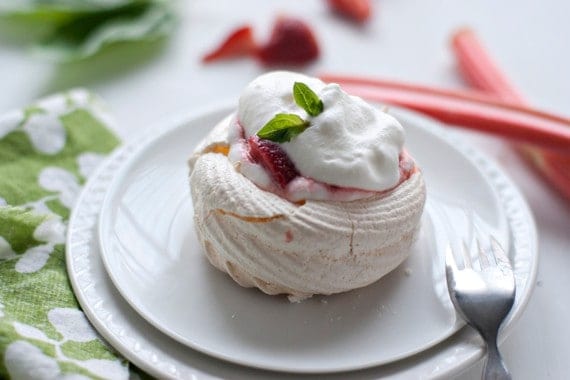 A meringue next on a round plate next to a fork
