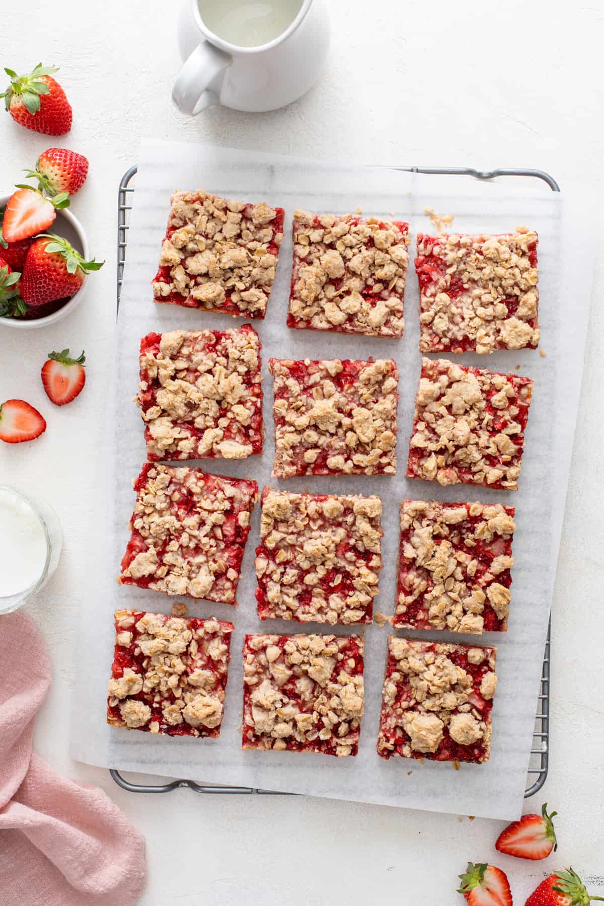 Overhead view of sliced strawberry oatmeal bars on a wire rack.