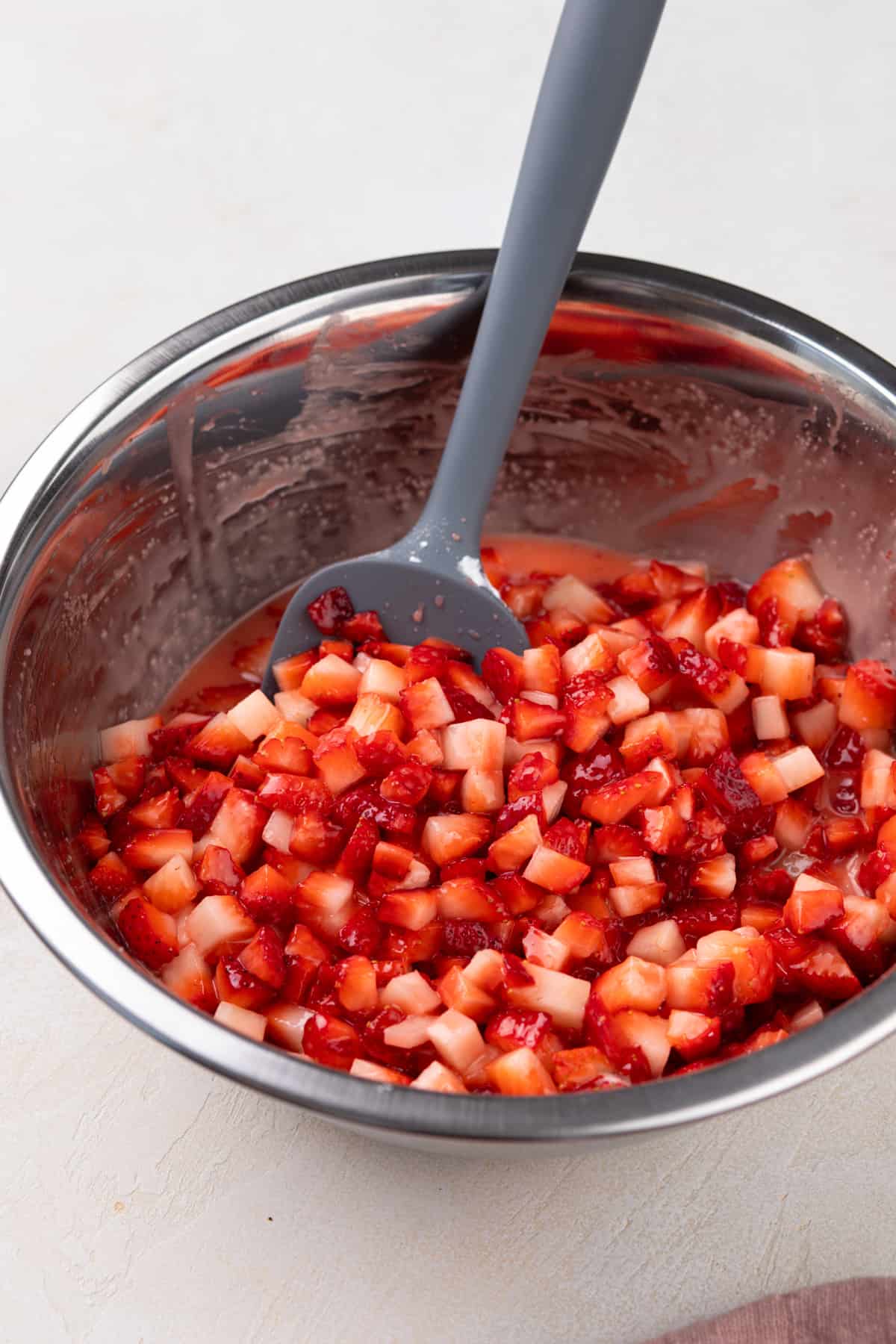 Strawberry filling for oat bars in a metal mixing bowl.