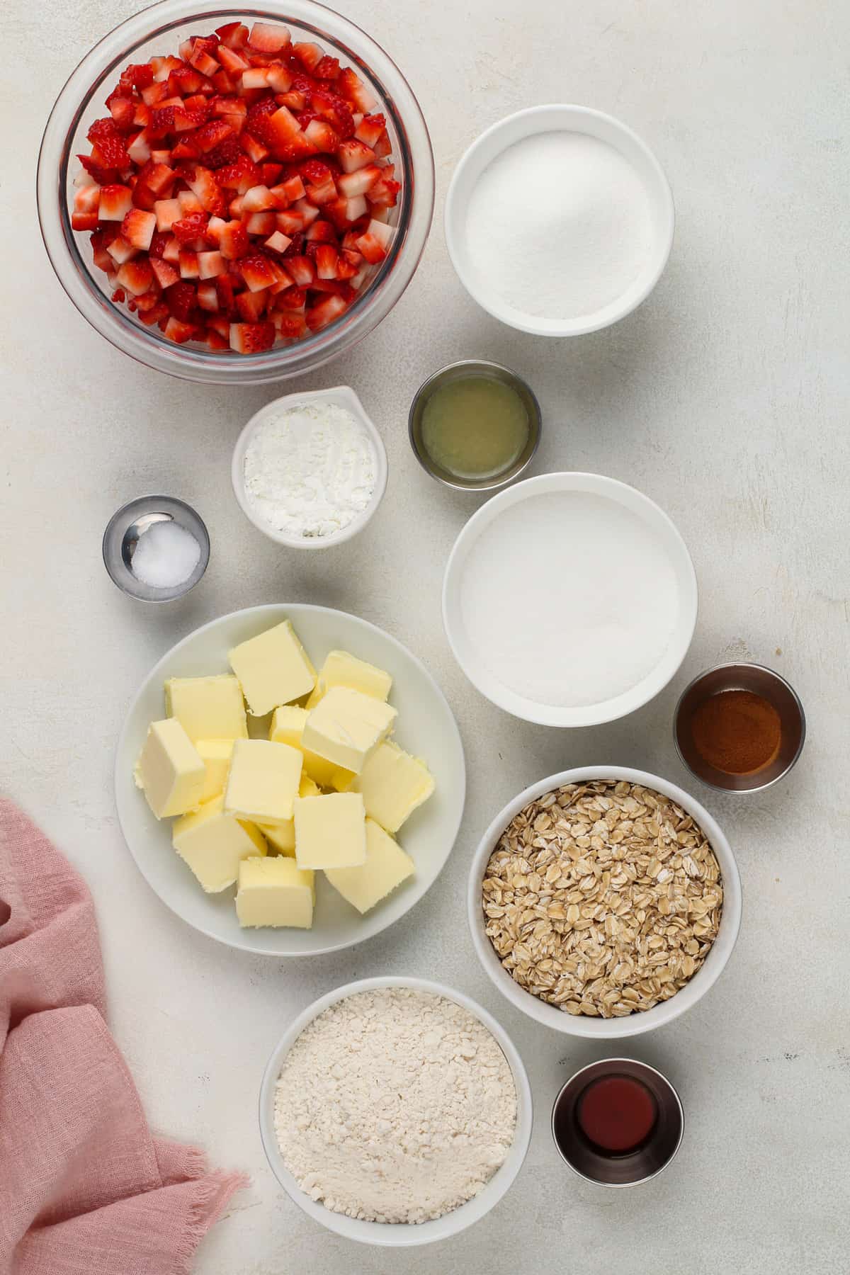 Ingredients for strawberry oatmeal bars arranged on a light-colored countertop.