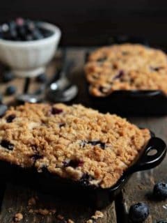 Blueberry buckle in a black baking dish on a wood surface