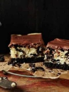 Two Oreo cheesecake brownies next to a glass of milk