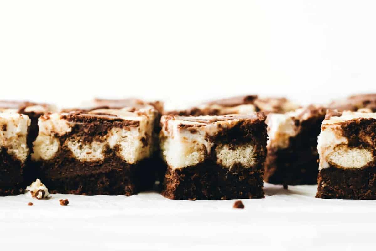 Side view of tiramisu brownies with brownie layer topped with ladyfingers and mascarpone filling