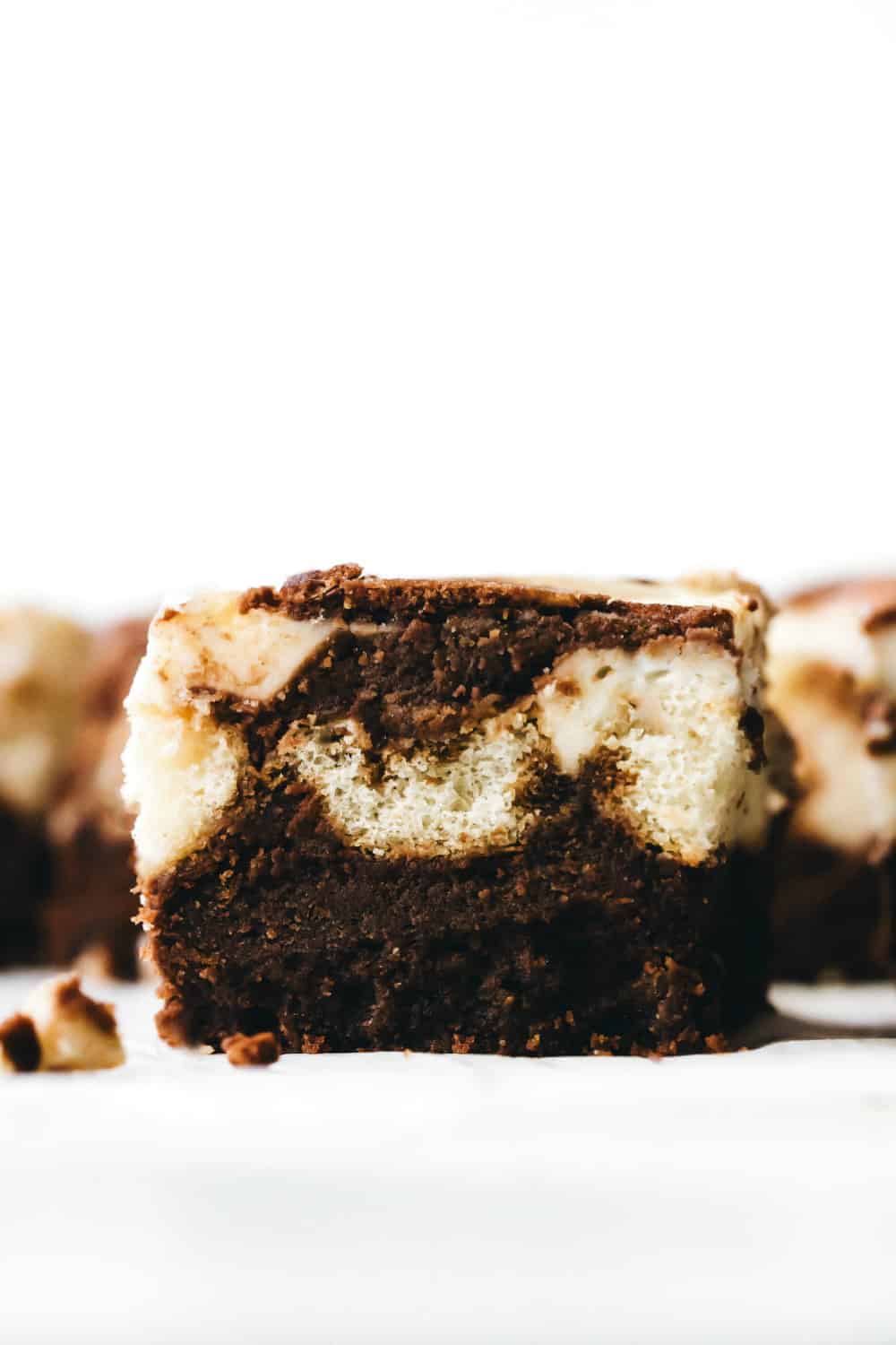 Close-up view of sliced tiramisu brownie showing brownie layer, ladyfinger layer and mascarpone layer.