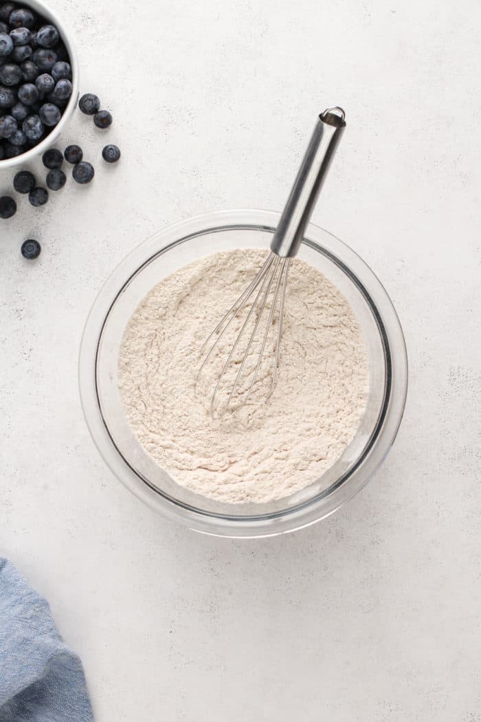 Dry ingredients for blueberry buckle whisked together in a glass mixing bowl.