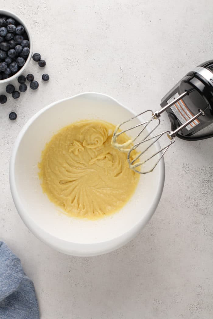 Wet ingredients for blueberry buckle mixed together in a white mixing bowl.